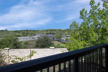 A balcony with a view of a city and trees